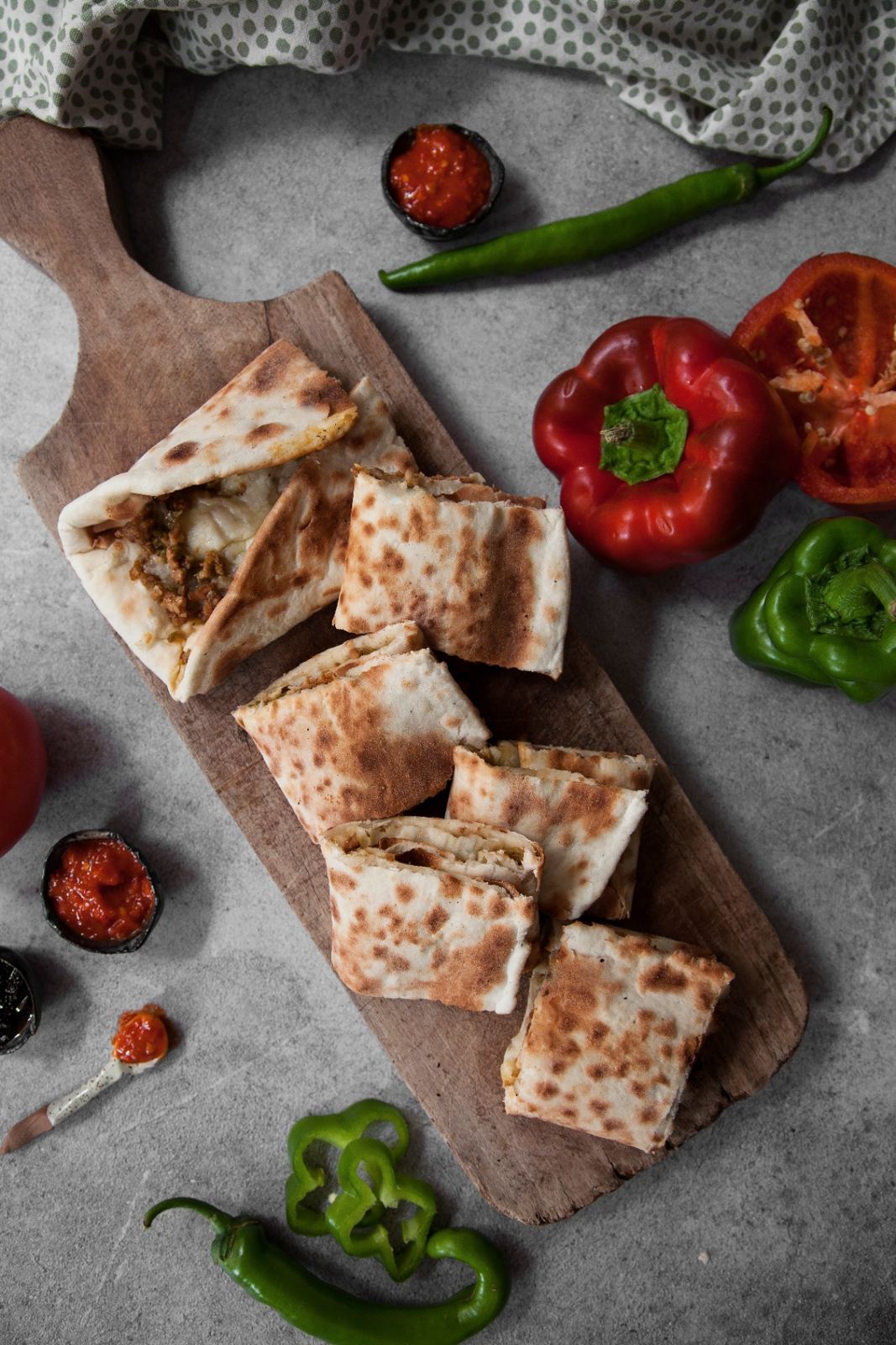 Arayes sliced on a wooden board with peppers